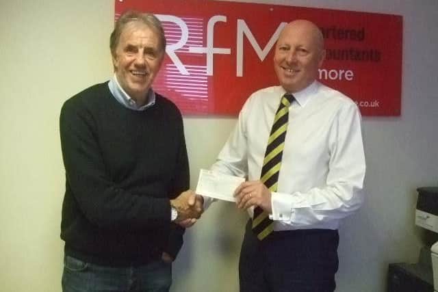 Paul, a long-time supporter of the charity Baby Beat, handing over a cheque to patron Mark Lawrenson.