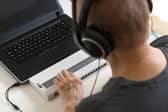 Global Accessibility Awareness Day focuses on digital access and inclusion for people with disabilities or impairments. (Image shows visually impaired person working on computer with assistive technology) 