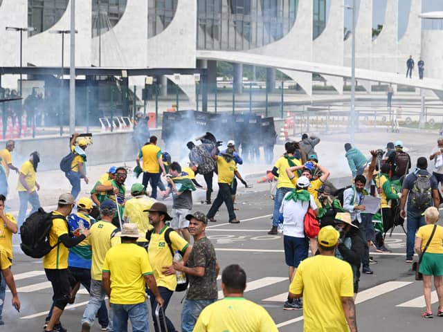 Supporters of Brazilian former President Jair Bolsonaro clash with the police during a demonstration outside the Planalto Palace in Brasilia on January 8, 2023. - Brazilian police used tear gas Sunday to repel hundreds of supporters of far-right ex-president Jair Bolsonaro after they stormed onto Congress grounds one week after President Luis Inacio Lula da Silva's inauguration, an AFP photographer witnessed. (Photo by EVARISTO SA / AFP) (Photo by EVARISTO SA/AFP via Getty Images)