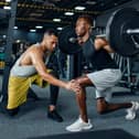Man with his trainer in gym (Adobe)