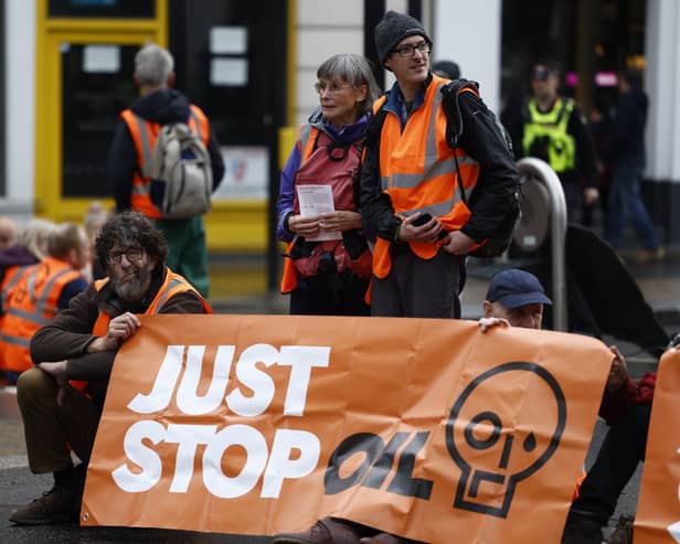 'Just Stop Oil' protesters block the road at the junction of Cannon St and Queen Victoria St on October 27, 2022 in London, England.