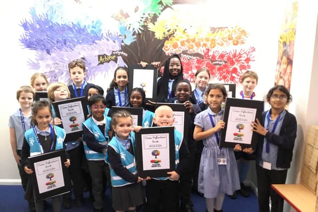 Pupils holding 'class reflection books' where children respond to their learning about equality, fairness, justice and respect.