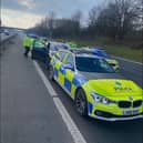 Dramatic pictures show the black Jaguar, worth up to £80,000 new, wedged in between two police cars from Merseyside Police on the eastbound carriageway between J11 for Birchwood and J12 for Eccles.