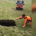 Hiker points to a giant sinkhole estimated to be around 20m deep