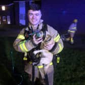 Firefighter Archer gives oxygen therapy to a little dog rescued from a house fire.