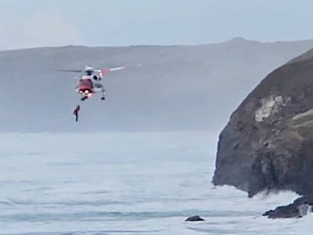 Footage capturing a dog walker being airlifted to safety after falling from a coastal path in Cornwall.  