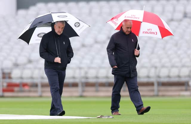 Match Umpires Peter Hartley and Paul Pollard inspect the pitch as play is cancelled during Vitality County Championship between Lancashire and Surrey