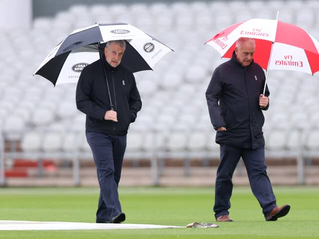 Match Umpires Peter Hartley and Paul Pollard inspect the pitch as play is cancelled during Vitality County Championship between Lancashire and Surrey