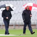 Match Umpires Peter Hartley and Paul Pollard inspect the pitch as play is cancelled during Vitality County Championship between Lancashire and Surrey