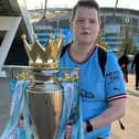 Jack, holding the Premier League trophy won by his club Manchester City.