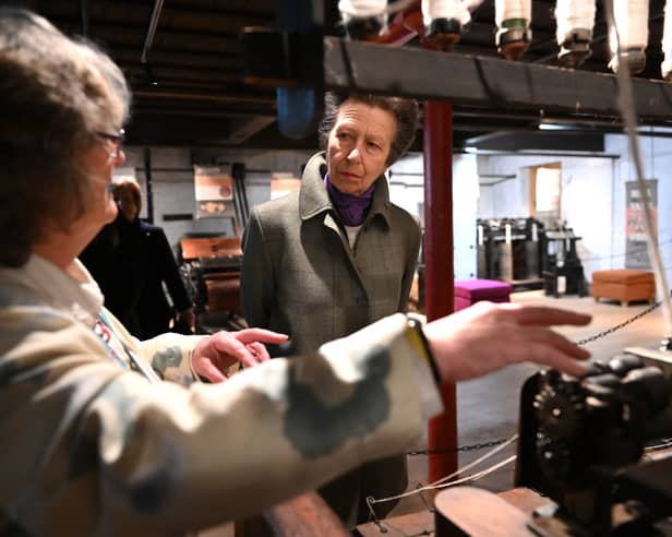 Princess Anne being talked through how some of the machines work at Helmshore Mills.
