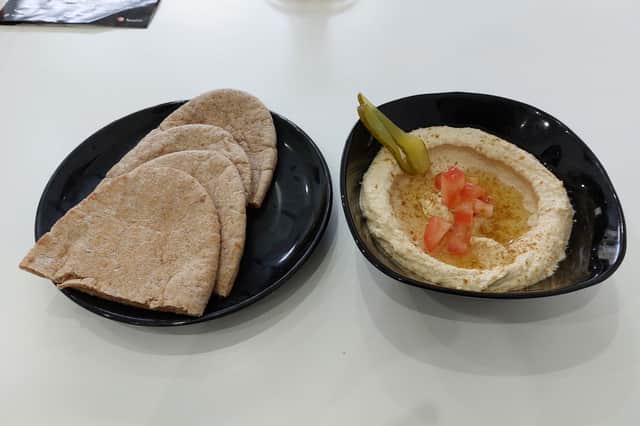 The portion of pita bread and accompanying hummus.