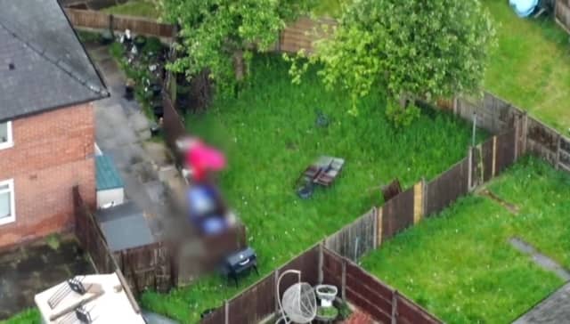 Suspect jumps fences in dressing gown to try and flee police.