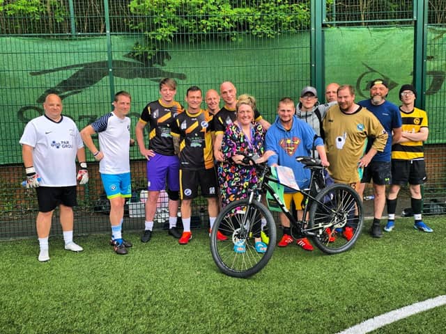 March being gifted his new bike by players at Senior Soccer.