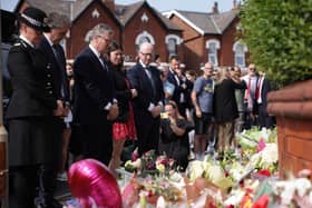Prime Minister Sir Keir Starmer observes the floral tributes near the scene in Hart Street, Southport