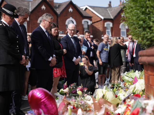 Prime Minister Sir Keir Starmer observes the floral tributes near the scene in Hart Street, Southport
