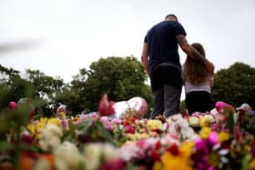 Members of the public take part in a vigil outside the Town Hall in Southport, ahead of a vigil, in memory of three children who died in a "ferocious" knife attack