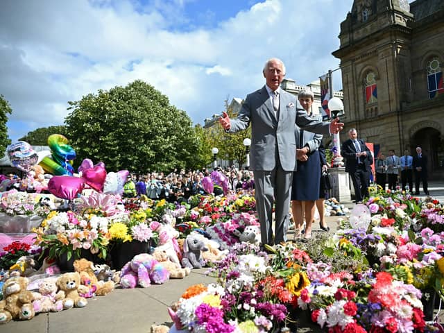 King Charles III reacts as he views tributes outside Southport Town Hall, during his visit to meet with members of the local community.