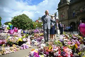King Charles III reacts as he views tributes outside Southport Town Hall, during his visit to meet with members of the local community.