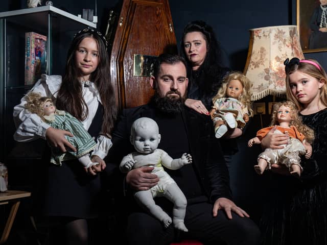 JP Kennedy and Kymmi Jeffery with daughters Snow and Pebble (L-R), known as The Occult Family, holding haunted dolls inside their haunted room.
