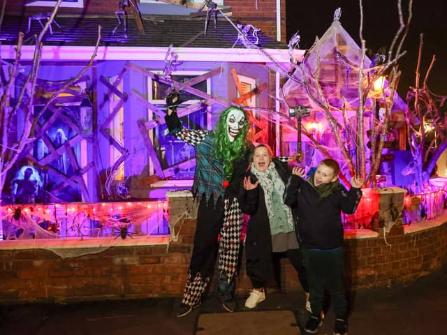 Elliot Smith dressed as a Corn Maze Clown with visitors Penny Unitt and Charlie outside his Halloween house in Stafford.