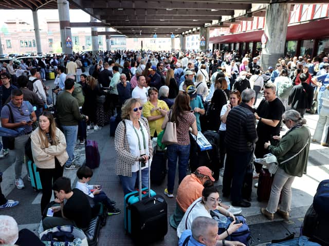 People wait outside the Atocha train station in Madrid after its closure as a massive power outage hits Spain.