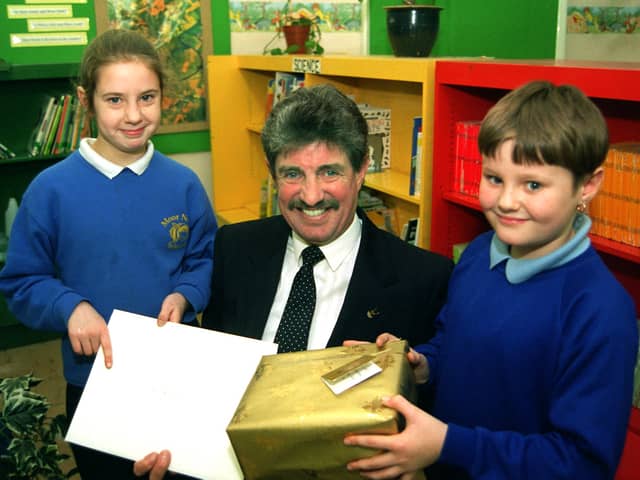 Graham Robinson is retiring after 13 years as headteacher at Moor Nook Primary School, Preston. He is pictured here receiving his leaving gift from pupils Laura Booth and Keith Stocks.