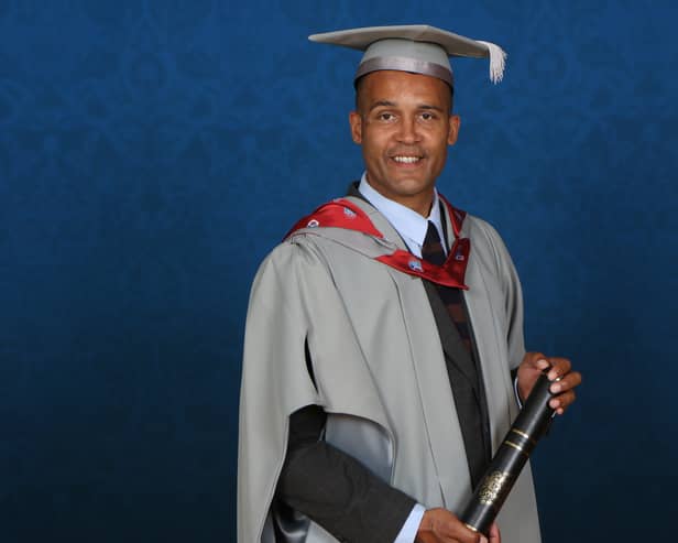 Clarke Carlisle holding his Honorary Fellowship from the University of Central Lancashire.