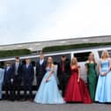 A large group in front of their limo