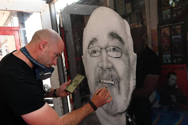 A mural of Malcolm Allen in the window of his Chorley town centre shop Malcolm's Musicland.  