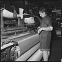 Power looms were developed in Lancashire mills for the mass production of woven cloth in towns like Blackburn and Burnley. This photo shows a weaver preparing a shuttle for use in a power loom 