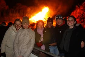 Visitors to the firework display at Preston Grasshoppers enjoy some warmth from the bonfire