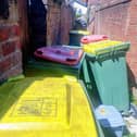 Recycling bins and food waste caddies in an alleyway off Armstrong Street in Ashton