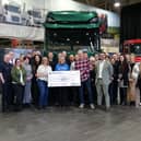 Sarah (seventh from the left) and her husband Michael present Rosemere Cancer Foundation’s Sue Swire (centre) with Sarah’s donation, watched by some of the colleagues who have supported her fundraising