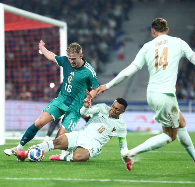 Kylian Mbappe fights for the ball with Ali McCann 