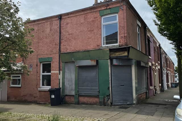 The fading “Fresh Cut Flowers” sign at No. 50, a surviving reminder of Oldham’s former grocery and florist’s shop