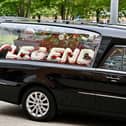 A floral tribute spelling "legend" in the hearse