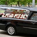 A floral tribute spelling "legend" in the hearse