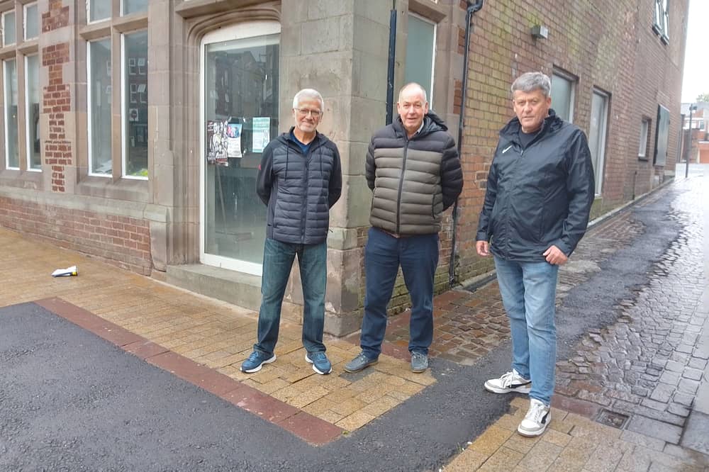 The patched-up pavement on Aughton Street in Ormskirk being assessed by Our West Lancashire county councillors Gordon Johnson (right) and Adrian Owens (centre), along with local resident Steve Kyriacou 