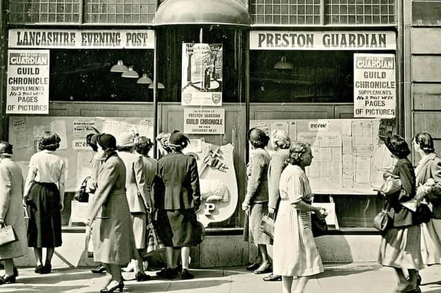 Crowds gather outside the Lancashire Evening Post and Preston Guardian offices on Fishergate during Preston Guild in 1952, with special Guild publications displayed in the windows