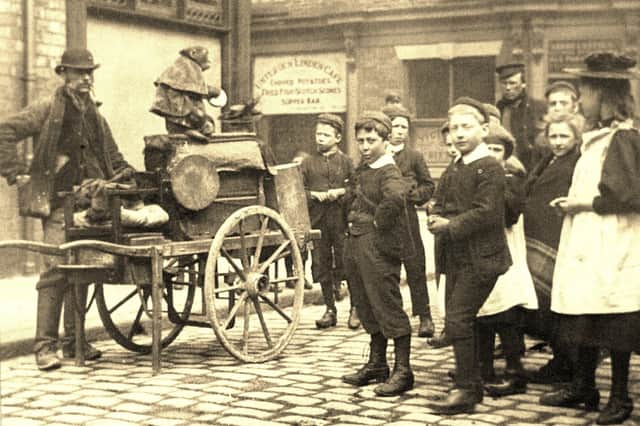 An organ grinder entertains a crowd of children in this nostalgic scene from Chorley's market days