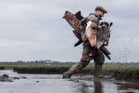 A wildfowler carries shot birds across the Ribble Estuary, where an award-winning documentary explores the relationship between shooting and conservation