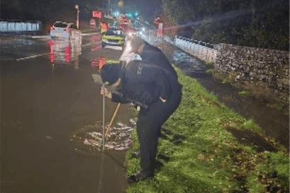 Lancashire Police clearing storm drain flooding in Accrington, during Storm Boelo