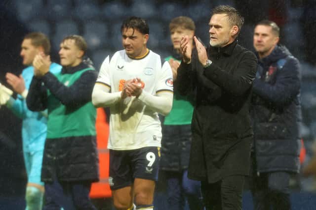 Preston North End manager Graham Alexander joins his players as they applaud the fans at the final whistle