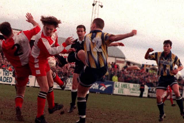 Preston substitute Micky Norbury sees a shot blocked in a scramble against Kidderminster in January 1994