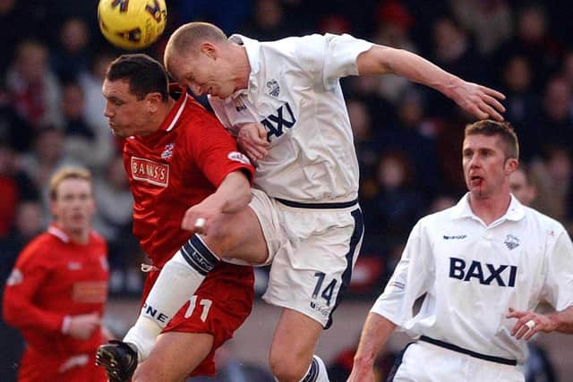Preston defender Colin Murdock wins a header against Walsall, watched by team-mate Chris Lucketti