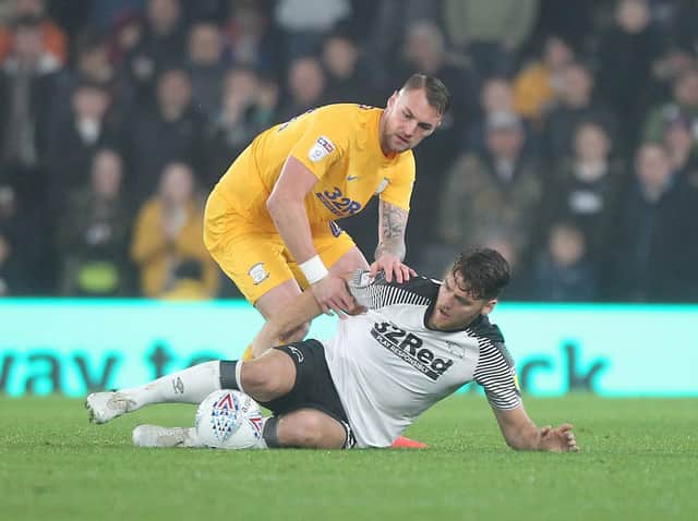 Preston centre-half Patrick Bauer tussles with Derby striker Chris Martin