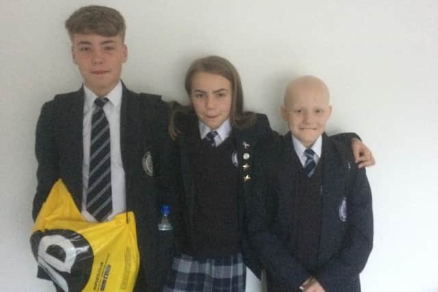 Joel pictured on his first day at Longridge High School in September. He is pictured with his brotherJake and sister Jasmine