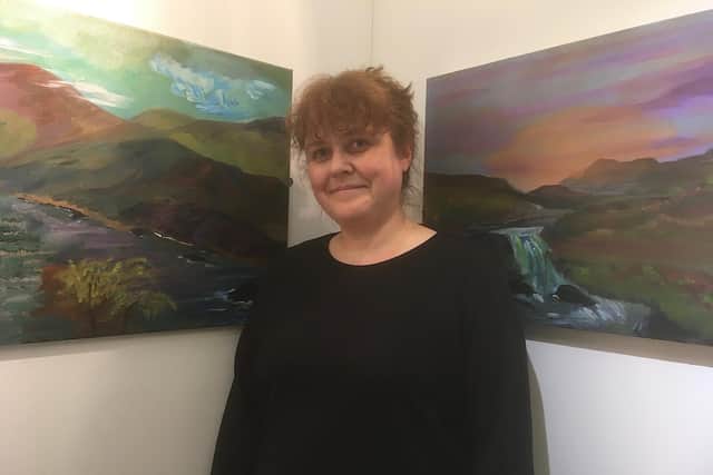 Claire Sutton, Clitheroe Castle Museum Manager, pictured with two of Owen's paintings