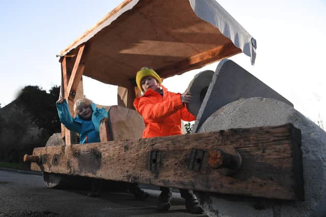 Charlie and Matthew in the Flintstones caveman car that has appeared in Walmer Bridge (Image: JPIMedia)